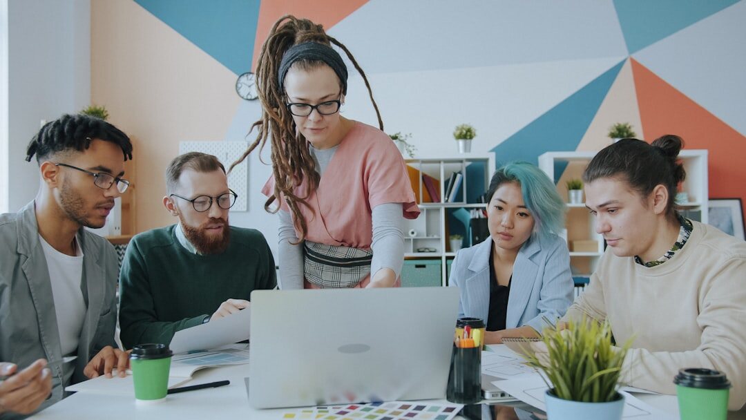 Diverse team of young developers collaborating around a laptop