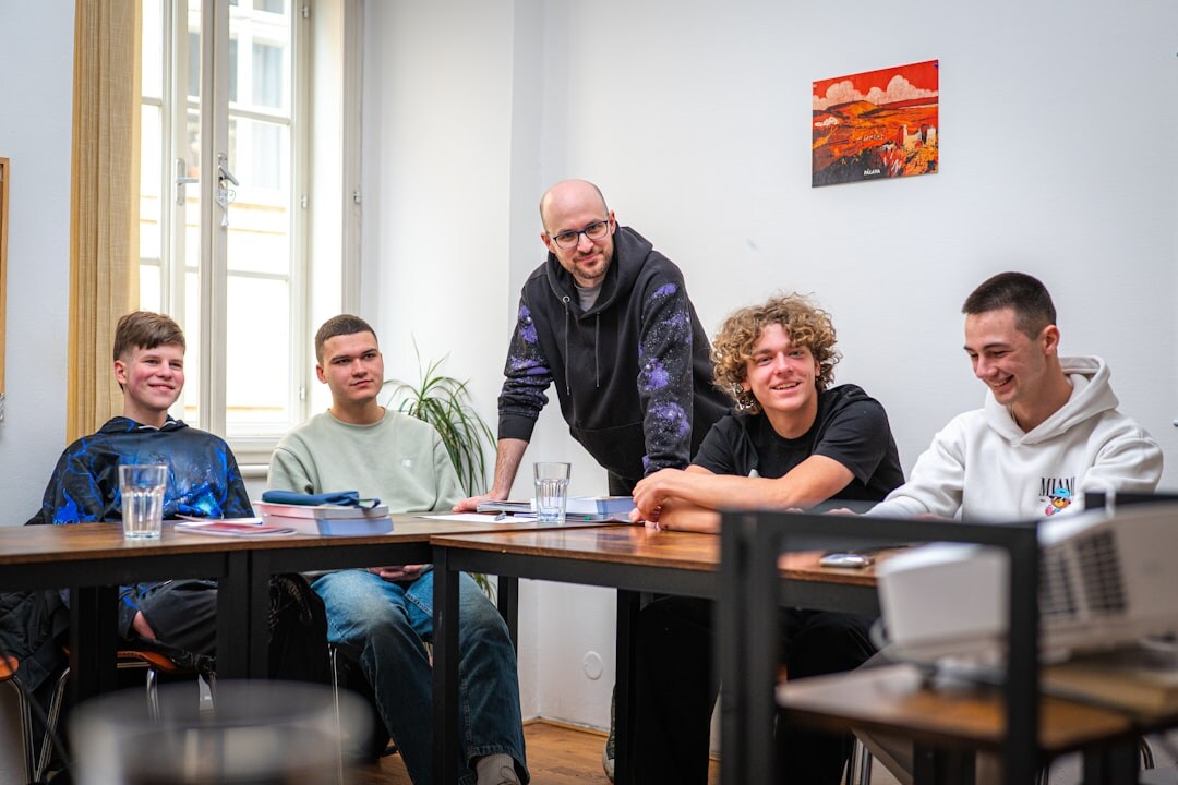 Group of programming students working on laptops in a bright classroom